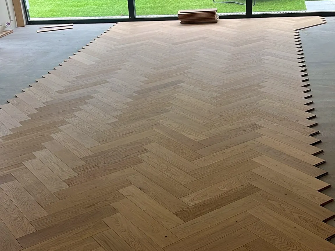 Le motif bâton rompu progresse vers la baie vitrée du jardin, chantier Wood Floors à Wemmel